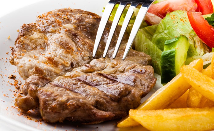 Bistecca alla griglia con insalata fresca e patatine – specialità di carne del ristorante Marina sul Naviglio